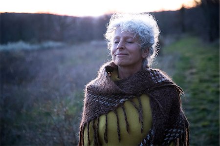 simsearch:649-08924209,k - Portrait of mature grey haired woman with eyes closed in dusk landscape Stock Photo - Premium Royalty-Free, Code: 649-08923221