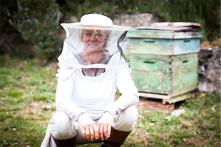 Portrait of female beekeeper crouching in garden Foto de stock - Sin royalties Premium, Código: 649-08923258