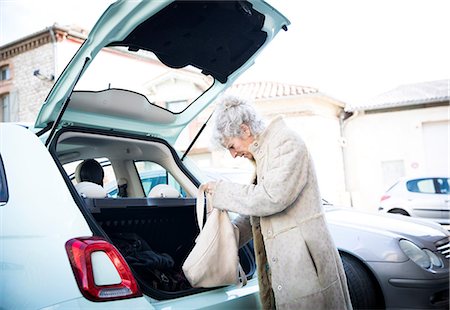 Mature woman with shopping bag looking in car trunk Stock Photo - Premium Royalty-Free, Code: 649-08923274