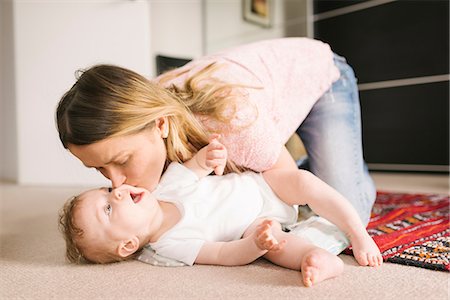 Mother kissing baby on rug Stock Photo - Premium Royalty-Free, Code: 649-08923609