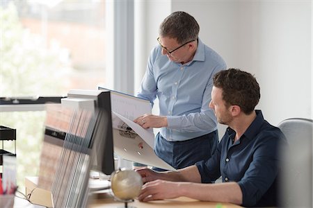 Male colleagues in discussion at office desk Stock Photo - Premium Royalty-Free, Code: 649-08923635