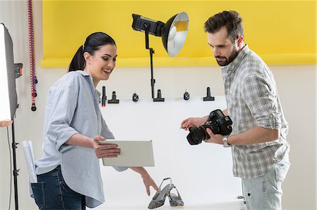 Stylist and photographer looking at digital tablet in photography studio Stock Photo - Premium Royalty-Free, Code: 649-08923850