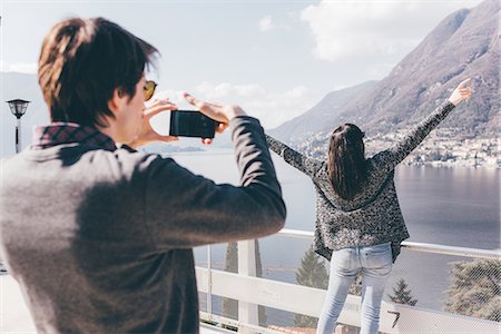 Man photographing girlfriend at lakeside, Monte San Primo, Italy Stock Photo - Premium Royalty-Free, Code: 649-08949498