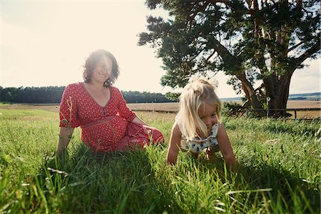 simsearch:649-08422552,k - Pregnant woman sitting in field with toddler daughter crawling in grass Foto de stock - Sin royalties Premium, Código: 649-08949898
