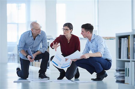 Colleagues working in office looking at blueprints Stock Photo - Premium Royalty-Free, Code: 649-08950487