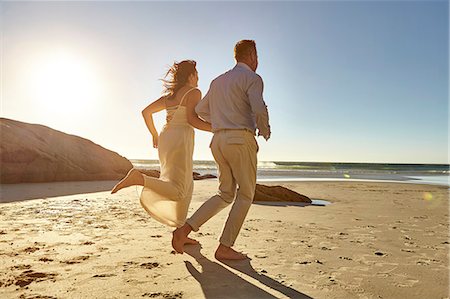 simsearch:614-07239972,k - Mature couple running along beach, hand in hand, rear view, Cape Town, South Africa Stock Photo - Premium Royalty-Free, Code: 649-08950590