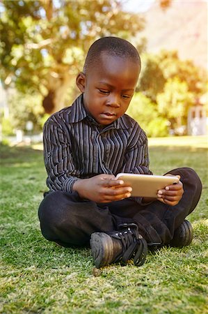 Boy playing game on cellular phone Foto de stock - Sin royalties Premium, Código: 649-08950620