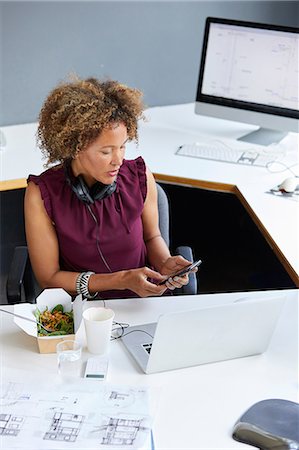 simsearch:649-06845199,k - Female designer looking at smartphone during working lunch at office desk Stock Photo - Premium Royalty-Free, Code: 649-08950780