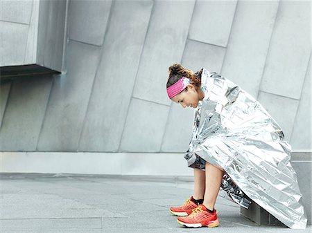 female wearing trainers - Mature female ultra runner wrapped in foil blanket in city Stock Photo - Premium Royalty-Free, Code: 649-08951065