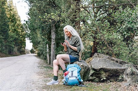 simsearch:649-08086253,k - Mature female backpacker looking at smartphone on forest road, Scandicci, Tuscany, Italy Stock Photo - Premium Royalty-Free, Code: 649-08951150