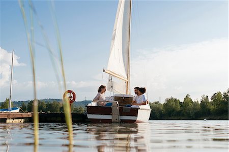 simsearch:614-00602699,k - Three friends relaxing on sailing boat on lake Stock Photo - Premium Royalty-Free, Code: 649-08969304