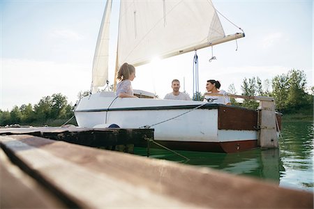 simsearch:614-00602699,k - Three friends relaxing on sailing boat on lake Stock Photo - Premium Royalty-Free, Code: 649-08969301