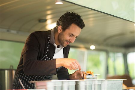 stand (vendor) - Small business owner serving food from van food stall hatch Photographie de stock - Premium Libres de Droits, Code: 649-08969552