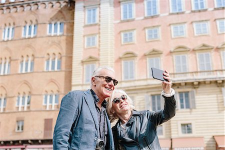 Tourist couple taking smartphone selfie in city, Siena, Tuscany, Italy Stock Photo - Premium Royalty-Free, Code: 649-08987805