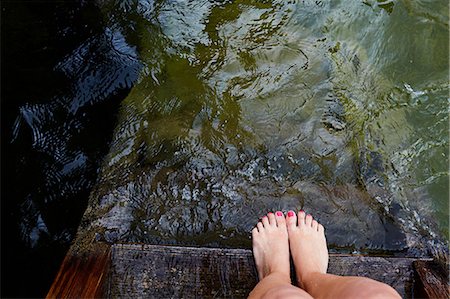 steps high angle - Woman's feet at edge of wooden pier by water Stock Photo - Premium Royalty-Free, Code: 649-08988416