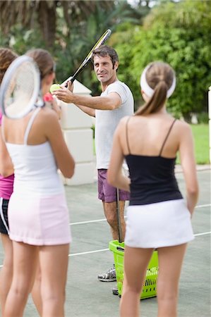 Tennis coach demonstrating for students Foto de stock - Sin royalties Premium, Código: 649-09002601