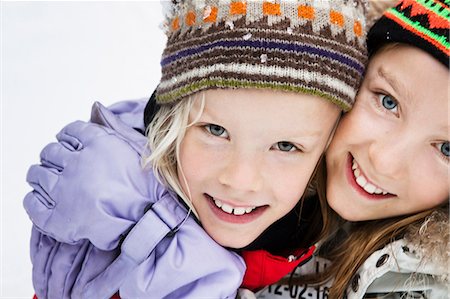 simsearch:632-01156716,k - Smiling girls hugging in snow Photographie de stock - Premium Libres de Droits, Code: 649-09003430