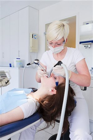simsearch:649-07280884,k - Dentist working on patients teeth Foto de stock - Sin royalties Premium, Código: 649-09003461