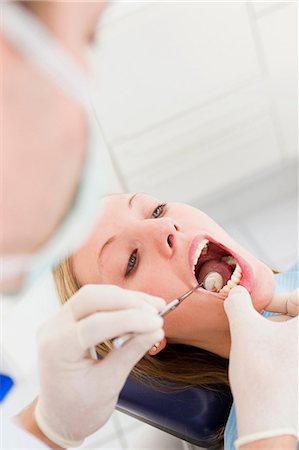 simsearch:649-07280884,k - Dentist working on patients teeth Foto de stock - Sin royalties Premium, Código: 649-09003475