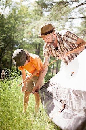 Father and son pitching tent in forest Stock Photo - Premium Royalty-Free, Code: 649-09003671