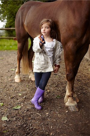 Girl brushing horse's coat outdoors Foto de stock - Sin royalties Premium, Código: 649-09003829