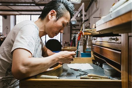 simsearch:649-07710266,k - Male jeweller inspecting metal at workbench Stock Photo - Premium Royalty-Free, Code: 649-09016559