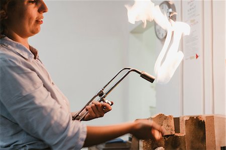 simsearch:6118-08202525,k - Female jeweller using flaming  blow torch at workbench Stock Photo - Premium Royalty-Free, Code: 649-09016568
