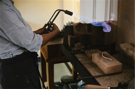 simsearch:6118-08202525,k - Mid section of female jeweller using flaming  blow torch at workbench Stock Photo - Premium Royalty-Free, Code: 649-09016569