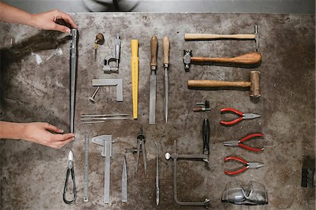 simsearch:6118-08202525,k - Overhead view of female jeweller's hands laying out hand tools at workbench Stock Photo - Premium Royalty-Free, Code: 649-09016577