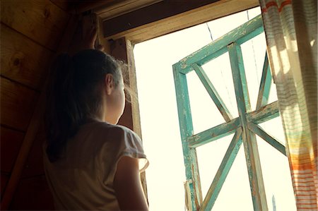 simsearch:649-07239584,k - Teenage girl looking out of sunlit bedroom window Stock Photo - Premium Royalty-Free, Code: 649-09016601