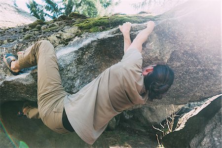 Young male boulderer climbing edge of boulder, Lombardy, Italy Stock Photo - Premium Royalty-Free, Code: 649-09016781