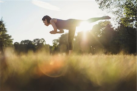 simsearch:614-08065889,k - Mature woman in park, balancing on one leg, in yoga position, low angle view Stock Photo - Premium Royalty-Free, Code: 649-09025375