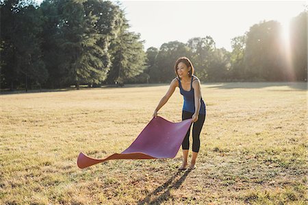 simsearch:614-08065889,k - Mature woman in park, laying yoga mat on grass Stock Photo - Premium Royalty-Free, Code: 649-09025377