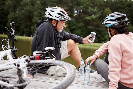simsearch:614-09078761,k - Mature couple relaxing on jetty beside lake, bicycles behind them Stock Photo - Premium Royalty-Free, Code: 649-09025925
