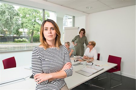 simsearch:649-07736470,k - Businesswoman, colleagues meeting in background Stock Photo - Premium Royalty-Free, Code: 649-09026090