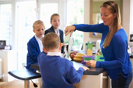 schoolgirl uniform - Mother pouring breakfast cereal for son in kitchen Stock Photo - Premium Royalty-Free, Code: 649-09026143