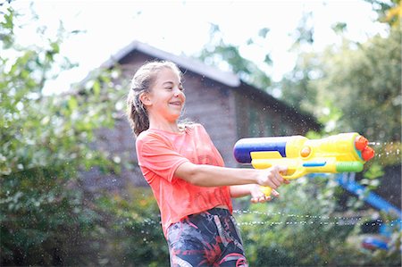simsearch:649-07239584,k - Teenage girl squirting water gun in garden Stock Photo - Premium Royalty-Free, Code: 649-09026196