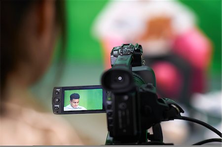 filming - Over shoulder view of college students practicing in TV studio with green screen Stock Photo - Premium Royalty-Free, Code: 649-09026216