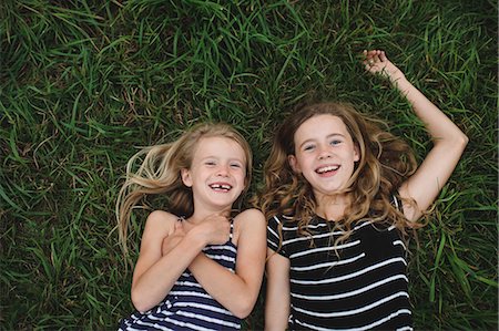 Overhead portrait of girl and her sister lying on grass Stock Photo - Premium Royalty-Free, Code: 649-09035542