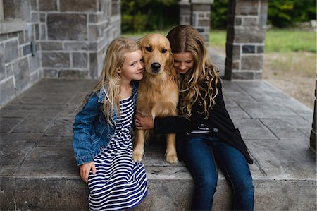 simsearch:649-06401393,k - Girl and her sister sitting on patio hugging their golden retriever Stock Photo - Premium Royalty-Free, Code: 649-09035543