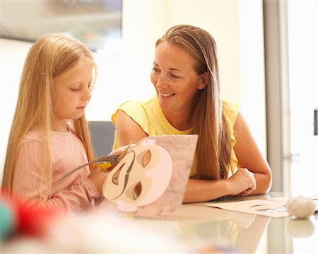 parents sitting with kids for crafts - Mother and daughter, sitting at table, making mask Stock Photo - Premium Royalty-Free, Code: 649-09035560