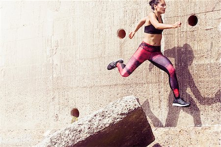 exhilarating - Young female free runner jumping across sea wall Stock Photo - Premium Royalty-Free, Code: 649-09035773