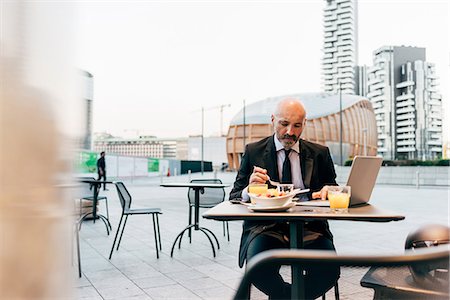 shaving (fragment) - Mature businessman sitting outdoors at cafe, using laptop Stock Photo - Premium Royalty-Free, Code: 649-09061353