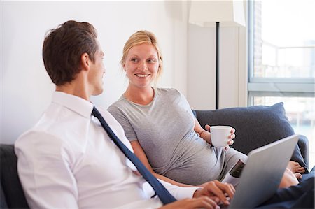 Pregnant couple sitting on sofa typing on laptop Stock Photo - Premium Royalty-Free, Code: 649-09061408