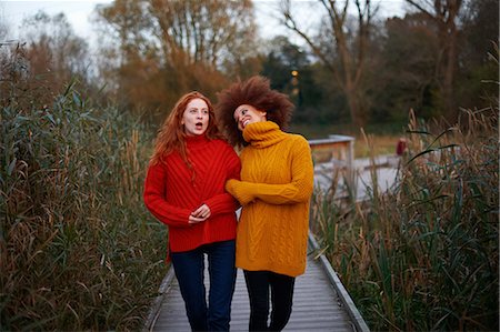 people smiling london - Two young women, walking arm in arm along rural pathway Stock Photo - Premium Royalty-Free, Code: 649-09078226