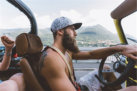 Young male hipster driving off road vehicle on road trip, Como, Lombardy, Italy Stock Photo - Premium Royalty-Free, Code: 649-09078266