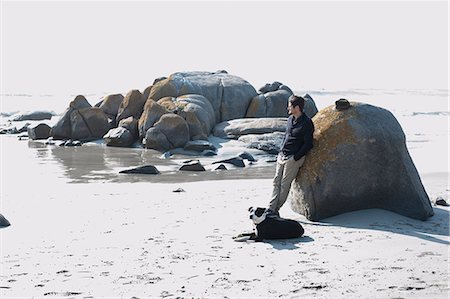 simsearch:649-09078617,k - Mid adult man with dog leaning against boulder gazing at sea, Cape Town, Western Cape, South Africa Stock Photo - Premium Royalty-Free, Code: 649-09078661