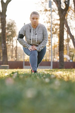 simsearch:695-05768377,k - Portrait of curvaceous young woman training in park, leaning forward and crouching Stock Photo - Premium Royalty-Free, Code: 649-09111307