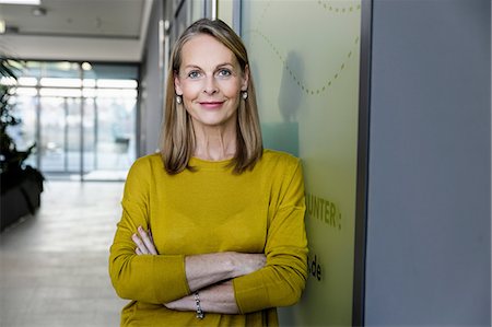 entre 50 y 60 años - Portrait of confident mature businesswoman in office corridor Foto de stock - Sin royalties Premium, Código: 649-09111600