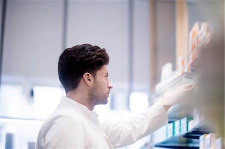 remove - Young male pharmacist removing medical drug from pharmacy shelves Stock Photo - Premium Royalty-Free, Code: 649-09111616